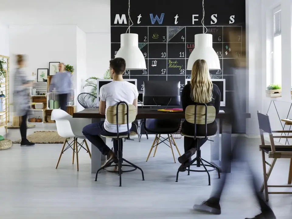 Vue de dos de deux collaborateurs qui travaillent dans un bureau flexible au sein d’un espace de coworking.