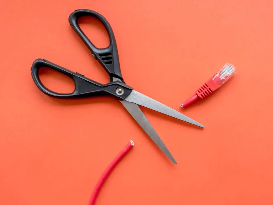 Ciseaux qui coupent un cable Ethernet pour symboliser le droit à la déconnexion au travail